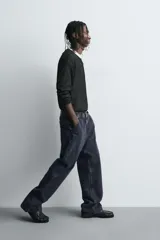Jeans relaxed fit de corte holgado y amplio en toda la pierna, color negro con efecto lavado. Presenta tiro medio, bolsillos frontales, bolsillos traseros de plastrón y aplicación de tira multifunción en la pernera. Cierre frontal con cremallera y botón.