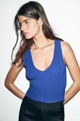 Top tejido de punto color azul eléctrico, con escote en V y sisas anchas.