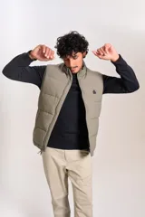 Chaleco puffer de corte regular, color beige, con cierre frontal y cuello alto. Presenta un diseño acolchado horizontal y logo bordado en el pecho.