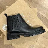 Bota tipo chelsea de cuero negro con paneles elásticos laterales, suela track dentada y taco cuadrado bajo.