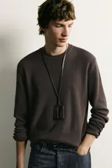 Sweater de punto color beige con textura tipo waffle, cuello redondo y mangas largas con acabado en rib.