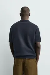 Polo de punto de algodón con corte regular, cuello solapa y cierre frontal de cremallera. Presenta manga corta y acabados en rib.