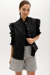 Chaleco celeste de lino con cuello mao, cierre frontal con botones y volados en hombros y bolsillos.