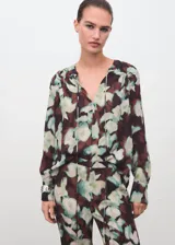 Pantalón de corte flare con estampado floral en tonos oscuros y verdes. Presenta tiro medio, cintura con elástico y forro interior.