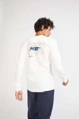 Remera de manga larga color mostaza, con cuello redondo y estampado frontal con las siglas MST en contorno verde.