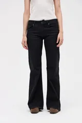 Jean de corte oxford en color negro, con ajuste en cintura y caderas, y piernas amplias. Presenta un diseño estructurado con cierre de botón y cremallera, y bolsillos clásicos.