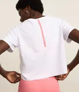 Remera cropped deportiva Get Over de microfibra texturizada con mini perforaciones, color blanco, de manga corta, con estampa pequeña en el frente y detalle contrastante en la espalda.