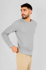 Buzo de manga larga color gris claro, con cuello redondo y detalle de costura en forma de V en la parte delantera del cuello. Presenta textura tipo waffle o panal de abeja.