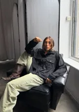 Campera marrón con cuello camisero, corte cuadrado, cierre frontal con botones y flecos en espalda y mangas.