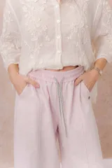 Pantalón de denim liviano color beige, de calce amplio y relajado con pierna recta. Cuenta con cintura elastizada, cordón regulable, bolsillos laterales y costuras delanteras verticales que estilizan la silueta.
