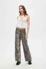 Pantalon de jean de corte ancho y tiro alto, con estampado tipo animal print desgastado en tonos gris y blanco.