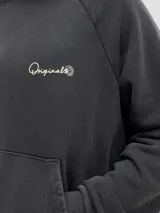 Canguro negro con capucha, de corte holgado y mangas raglán. Presenta un gran estampado en color beige en la espalda con la inscripción "Studio Originals" y texto descriptivo, además de puños y dobladillo acanalados.