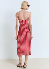Vestido midi de tirantes finos ajustables, con escote en pico y detalle fruncido en la parte frontal. Presenta un diseño recto con estampado de rayas verticales en tonos rojo y blanco.