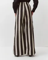 Pantalón amplio de algodón con rayas verticales en tonos negros y blancos, cintura elastizada, corte fluido y grandes bolsillos laterales con solapa de estilo cargo.