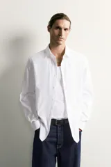 Camisa de corte slim fit confeccionada en tejido de fácil planchado, con cuello italiano, manga larga con puños abotonados y cierre frontal de botones.