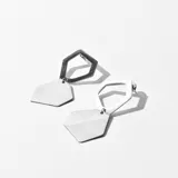Aros colgantes con forma geométrica, con un hexágono calado en la parte superior y un trapecio en la parte inferior.