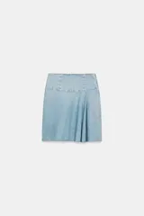 Falda midi de denim en tono azul claro, con tiro medio y diseño asimétrico con tablas laterales. Cuenta con cierre lateral mediante cremallera metálica.