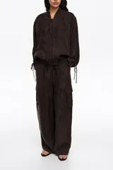 Pantalón cargo de corte barrel color marrón, confeccionado en mezcla de algodón, con bolsillos laterales con fuelle y cintura ajustable con cordón.