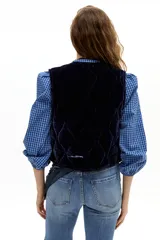 Chaleco capitoneado de terciopelo de seda, con cuello a la base y diseño sin mangas.