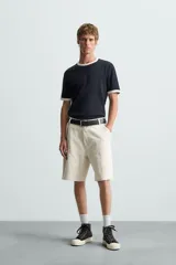 Bermuda relaxed fit confeccionada en tejido de algodón con efecto lavado. Presenta un diseño de cinco bolsillos, bolsillo multifunción en la pernera y tira lateral de estilo carpintero. Cuenta con cierre frontal con cremallera y botón.