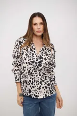 Camisa de manga larga con cuello clásico y cierre frontal de botones. Presenta un estampado de manchas tipo animal print en tonos blanco y negro.