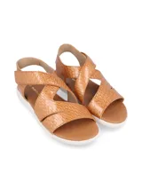 Sandalia de cuero con textura de reptil, diseño de tiras cruzadas en el empeine y cierre con velcro en el talón. Cuenta con una suela blanca flexible y liviana.