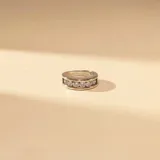 Anillo de banda ancha fabricado en plata y oro, con una hilera central de circonias engastadas.