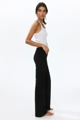 Pantalón negro de punto de algodón suave, con cintura ancha plegable y piernas rectas de corte acampanado.