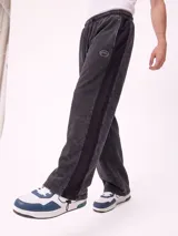 Pantalón jogger holgado de color gris con efecto acid wash y franjas laterales negras. Cuenta con cintura elástica con cordón ajustable y bolsillos laterales.