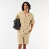 Bermuda de punto grueso color beige, de diseño liso, con bolsillos laterales y cintura elástica.