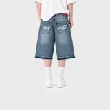 Bermuda baggy de denim azul con diseño amplio, bolsillos traseros grandes con estampas tipográficas blancas y dobladillo desmechado con detalle de costuras decorativas.