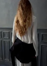 Blusa de poliéster color blanco con cuello redondo drapeado y mangas largas.