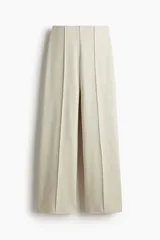 Pantalón de corte holgado confeccionado en punto fino de mezcla de algodón, con tiro alto y pliegues verticales cosidos en el frente.