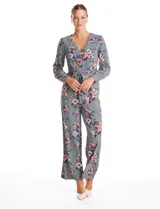 Enterito de crepe con estampado floral, escote en V, mangas largas con puños abotonados y lazo de ajuste en la cintura.