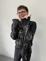 Remeron oversize de algodón pesado color negro con estampado gráfico en serigrafía gris en el frente y en ambas mangas. Presenta cuello redondo y grifa de la marca en el puño.