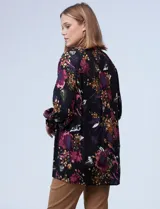 Blusa negra con estampado floral en tonos borgoña, rosa y blanco. Tiene cuello a la base con escote en V y botones.