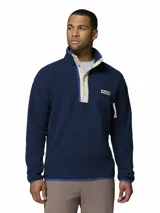 Polar Columbia Helvetia Half Snap azul marino, confeccionado en tejido suave de borreguito, con cuello alto, cierre frontal de botones a presión con solapa en tono beige y un bolsillo con cierre en el pecho con el logo de la marca.