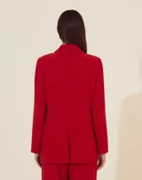 Blazer rojo con solapas de muesca, cierre frontal con dos botones y bolsillos de parche.