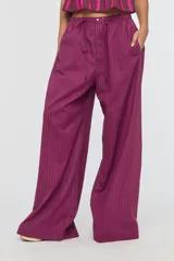 Pantalón de tiro medio con estampa a rayas en tonos fucsia y marrón oscuro, cintura elástica con cordón ajustable, bolsillos laterales y silueta amplia de corte recto.