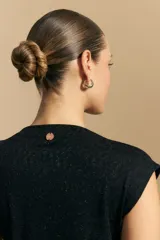 Top sin mangas de tejido texturizado con brillo integrado, color beige dorado, con cuello alto y hombros levemente estructurados.