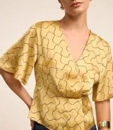 Blusa de mangas cortas con escote V traspasado, pliegues y recorte en la cintura. Confeccionada en tejido con efecto satinado y estampado geométrico con líneas curvas.