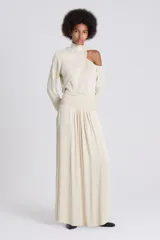 Falda larga color crema, de corte evasé y tejido satinado, con detalle de frunces en la cintura.