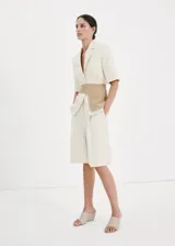 Short de mezcla de lino color beige con sutiles rayas verticales, diseño recto y tiro medio, con bolsillos laterales y trabillas para cinturón.