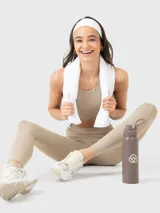Top deportivo color beige con espalda estilo nadador y almohadillas removibles.