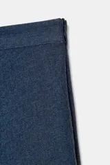 Falda midi azul oscuro, de tiro alto, con corte evasé y textura arrugada o plisada. Presenta un forro interior y cierre lateral oculto.