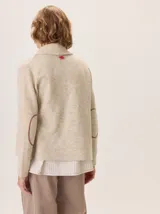Saco de lana hervida color negro, con cuello solapa, cierre frontal de botones rústicos y bolsillos laterales. Presenta un diseño clásico con coderas y textura artesanal.