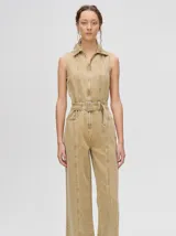 Enterito de denim color beige, sin mangas, con cuello camisero y cierre frontal. Incluye cinturón ajustable con hebilla metálica y piernas rectas de calce holgado.