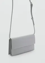 Bolso tipo sobre de diseño minimalista, color gris, con correa larga ajustable y cierre de solapa.