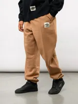 Pantalón jogger de felpa color tostado, con corte relajado, cintura elástica y etiqueta con logo de la marca en la parte delantera.