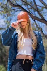 Gorra ajustable con visera color marrón de efecto cuero.